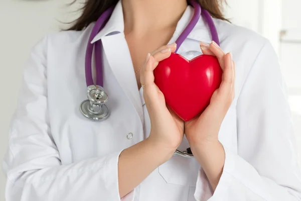 As mãos dos médicos do sexo feminino segurando coração vermelho — Fotografia de Stock