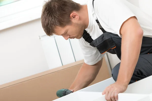 Man putting together self assembly furniture — Stock Photo, Image