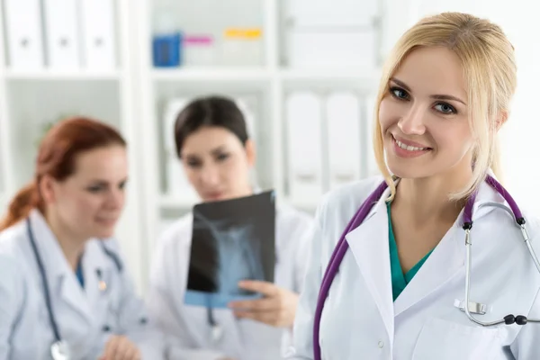 Retrato de médico feminino sorridente com dois colegas — Fotografia de Stock