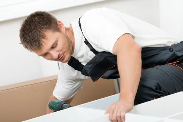 Mann stellt Möbel zur Selbstmontage zusammen — Stockfoto