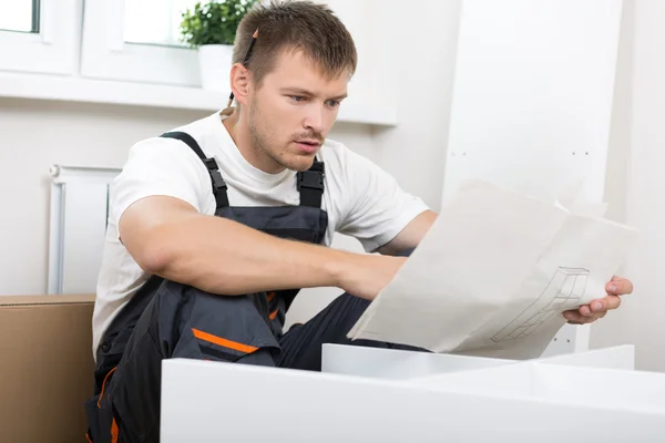 Frustrated man reading instruction — Stock Photo, Image