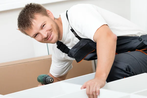 Man putting together self assembly furniture — Stock Photo, Image