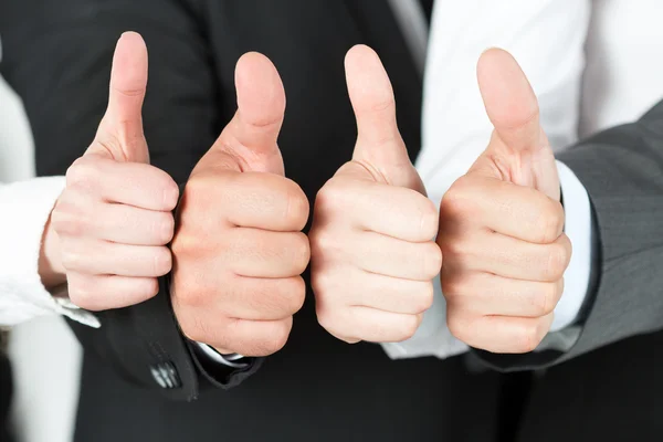 Business team pointing up their thumbs — Stock Photo, Image