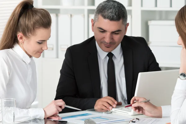 Uomo d'affari adulto che consulta la sua giovane collega donna — Foto Stock