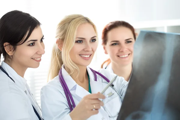 Tres doctora de medicina sonriente mirando la imagen de rayos X —  Fotos de Stock