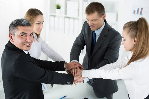 Equipo de negocios mostrando unidad con poner sus manos juntas — Foto de Stock