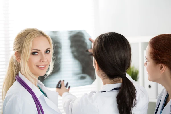 Portrait of smiling female medicine doctor with two colleagues — Stock Photo, Image