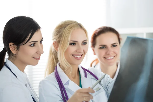 Portrait of three smiling female medicine doctors  looking at x- — Stock Photo, Image