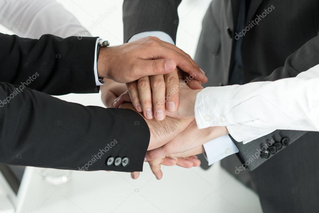 Closeup of business team showing unity with putting their hands 