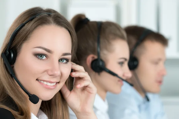 Portret van call center werknemer vergezeld door haar team — Stockfoto