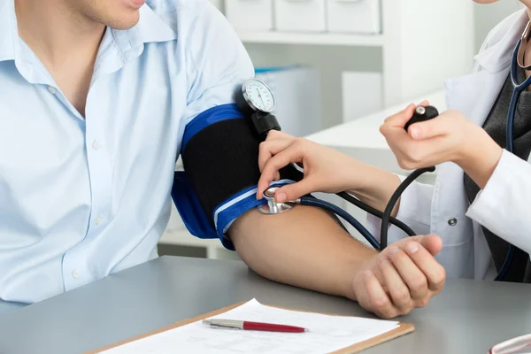 Medicina feminina médico mãos medir a pressão arterial — Fotografia de Stock