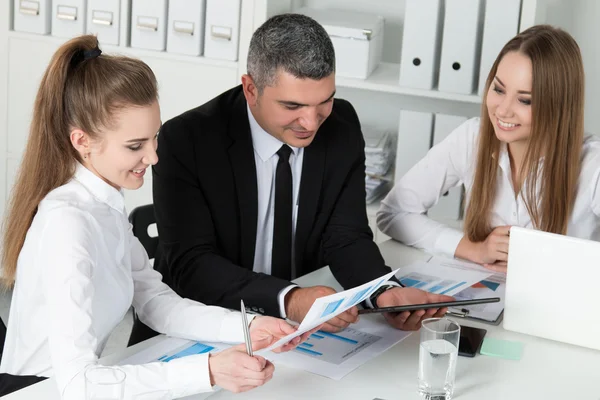 Erwachsener Geschäftsmann berät seine jungen Kolleginnen — Stockfoto