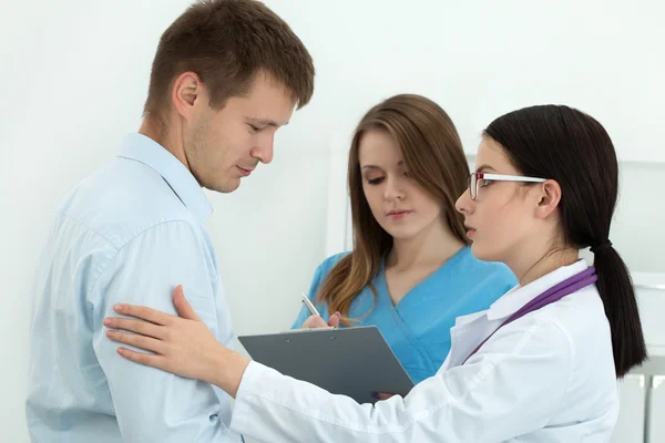 Amistosa doctora tocando el brazo del paciente masculino para empatía —  Fotos de Stock