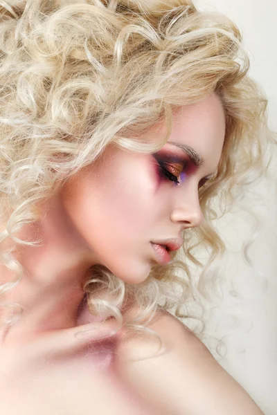 Портрет молодой женщины с кудрявыми светлыми волосами и модным макияжем — стоковое фото