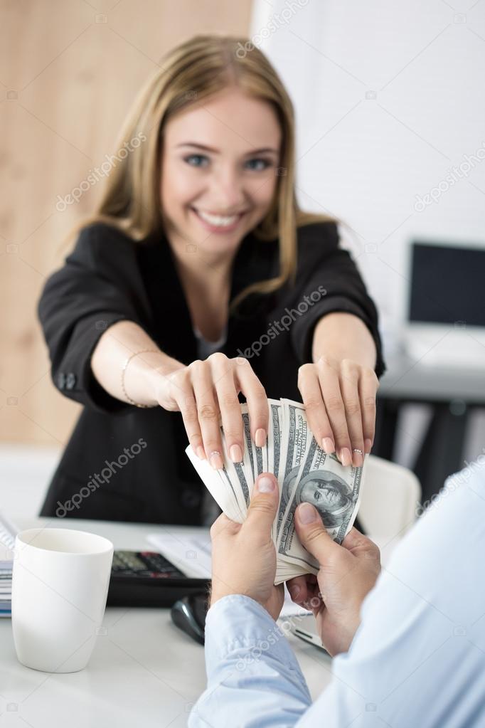 Woman taking batch of hundred dollar bills