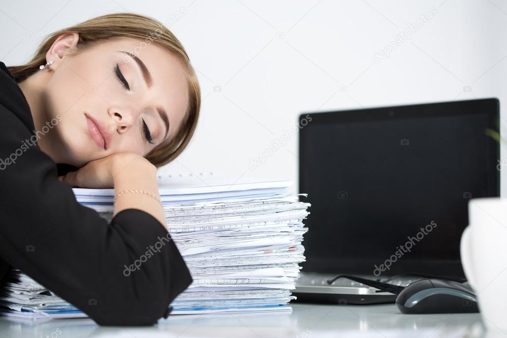 Tired business woman slleeping on heap of papers at her working