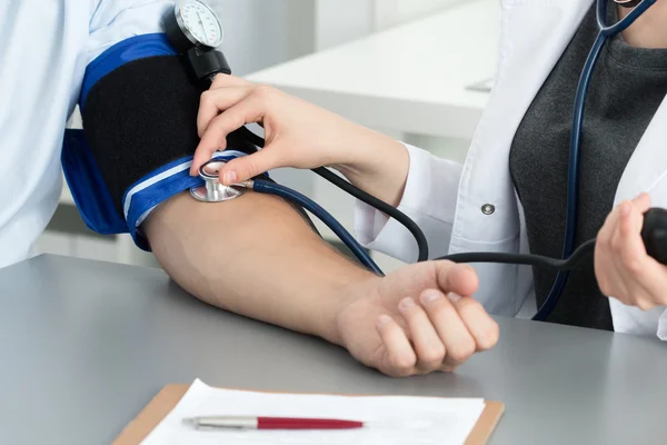 Medico femminile che misura la pressione sanguigna al suo paziente — Foto Stock