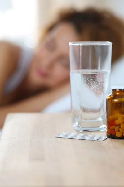 水と薬のベッドサイド テーブルの上に立ってのガラス — ストック写真
