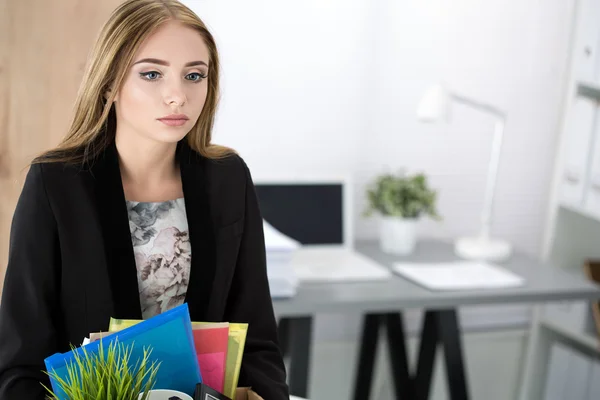 Junge entlassene Mitarbeiterin im Büro hält Karton mit — Stockfoto