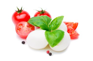 Mozzarella peyniri, domates ve fesleğen yaprakları üzerinde beyaz izole