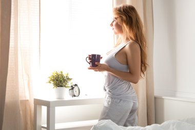 Pencere ve holdi yakın duran genç güzel gülümseyen kadın