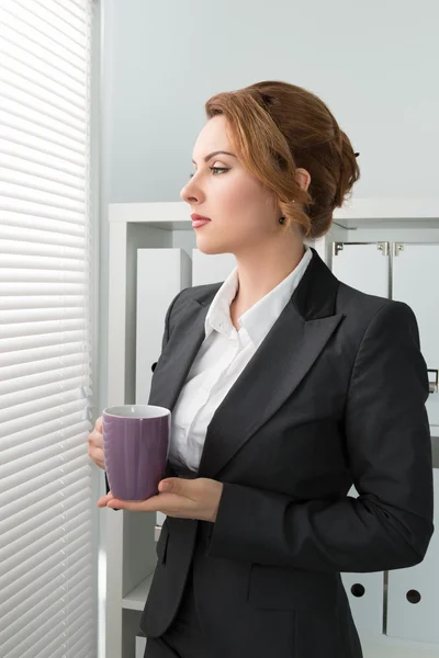 Üzleti nő az ablak mellett állandó és látszó kívül a — Stock Fotó
