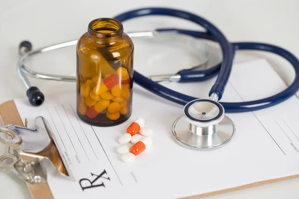 Medical stethoscope head with pile of tablets — Stock Photo, Image