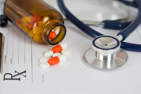 Medical stethoscope head with pile of tablets — Stock Photo, Image