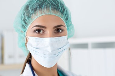 Close-up portrait of female medicine doctor wearing protective m