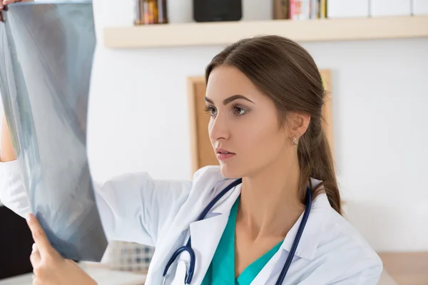 Ung kvinnlig läkare titta på lungorna röntgenbilden — Stockfoto