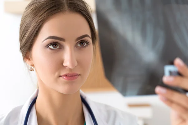 Young female doctor looking at hands x-ray image — Stock Photo, Image