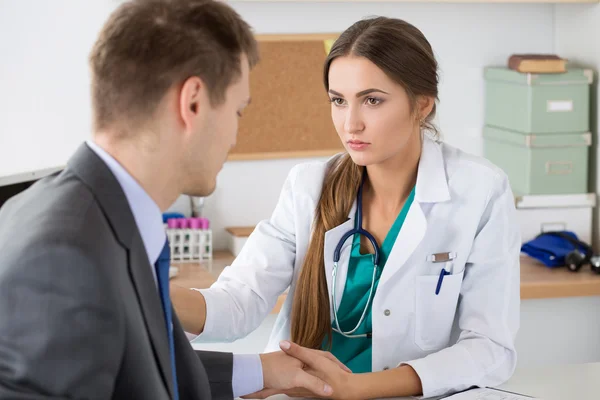 Amistoso médico de medicina femenino sosteniendo la mano del paciente masculino su —  Fotos de Stock