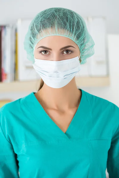 Portrait of female surgeon wearing protective mask and cup — Stok fotoğraf