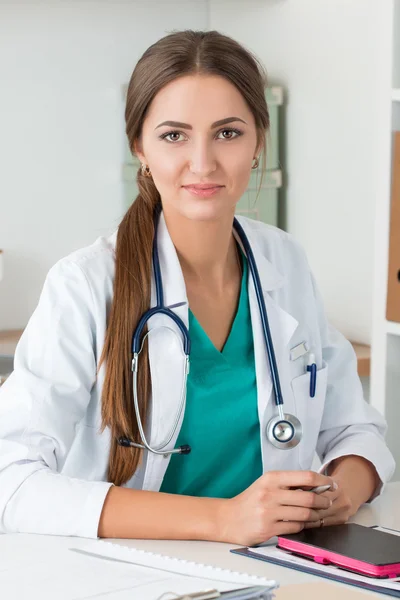 Porträtt av leende vänliga medicine doktor sitter vid hennes offi — Stockfoto