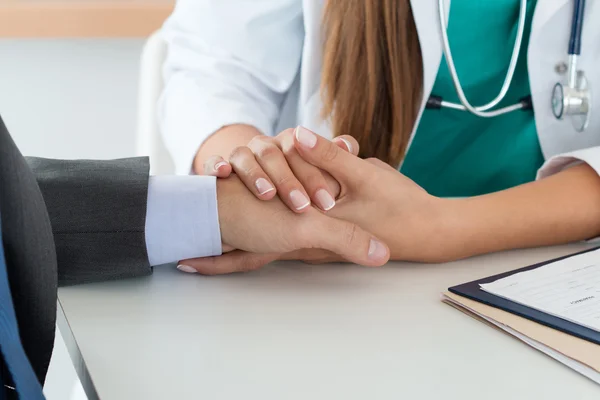 Nahaufnahme freundlicher Medizinerin, die männliche Hand hält — Stockfoto