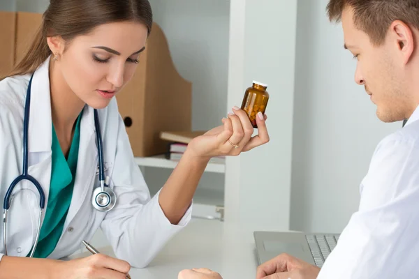 Médecine féminine médecin prescrivant des pilules à son patient masculin — Photo