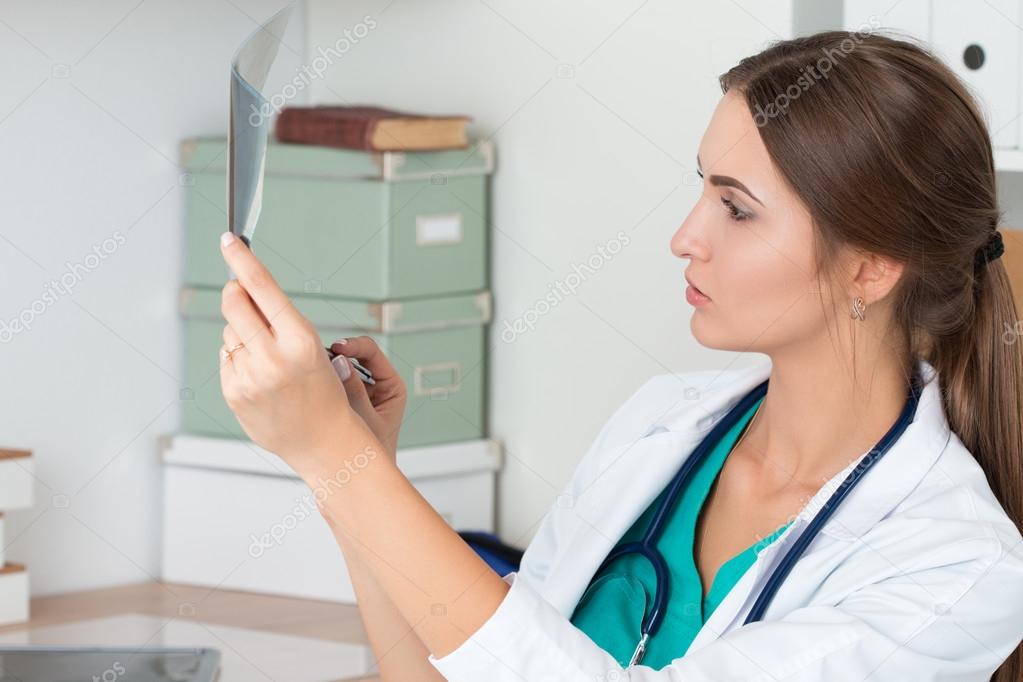 Young female doctor looking at lungs x-ray image