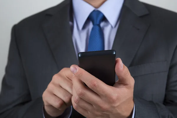 Nahaufnahme eines Geschäftsmannes, der sein Handy in der Hand hält — Stockfoto