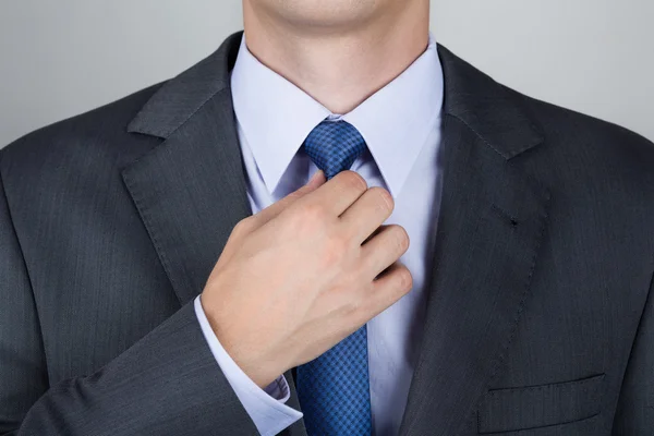 Business man adjusting his neck tie — Stock Photo, Image