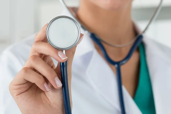 Närbild av kvinnliga läkare hand stetoskop huvud — Stockfoto