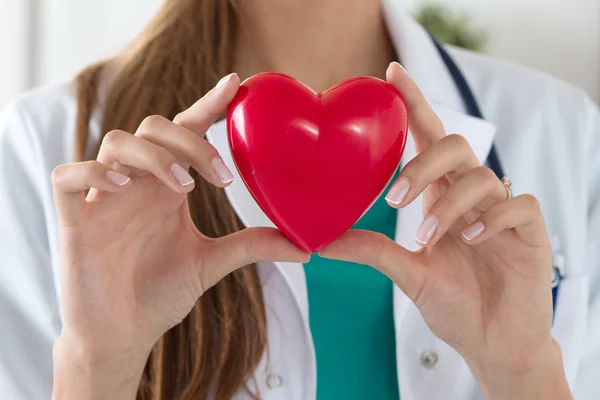 Primo piano di mani mediche femminili che tengono il cuore letto — Foto Stock