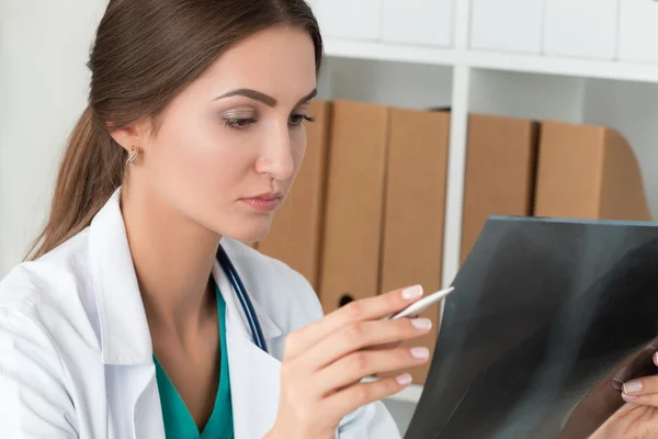 Young female doctor looking at lungs x-ray image — Stock Photo, Image