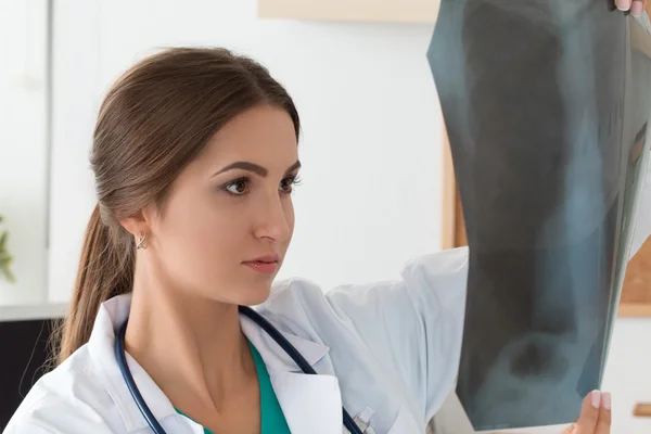 Joven doctora mirando la imagen de rayos X de los pulmones —  Fotos de Stock