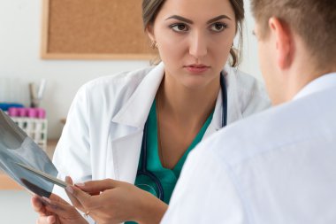 Genç kadın doktor ve onun erkek arkadaşı x-ray IMAG tartışıyor