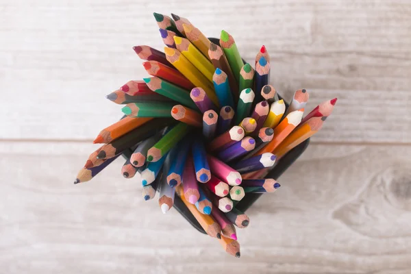 Ensemble de crayons colorés debout sur une table en bois — Photo