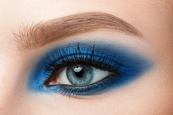 Primer plano de la mujer ojo azul con hermosos ojos ahumados azules makeu —  Fotos de Stock