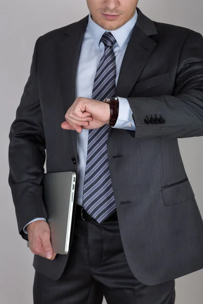 Young business man looking at his wristwatch checking the time — Stock Photo, Image