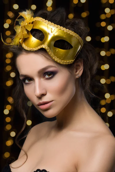 Portrait of beautiful young woman wearing golden party mask — Stock Photo, Image