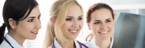 Porträtt av tre leende kvinnliga medicine läkare tittar på x- — Stockfoto