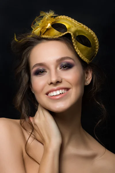 Portrait of young beautiful woman wearing golden party mask — Stock Photo, Image